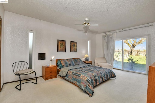 carpeted bedroom featuring ceiling fan, access to exterior, and a textured ceiling