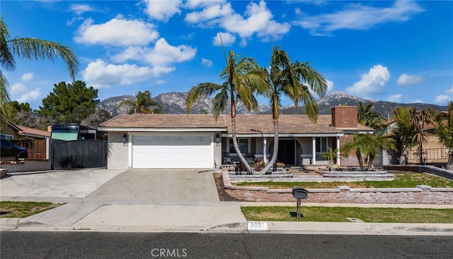 ranch-style house with concrete driveway, a mountain view, an attached garage, and stucco siding