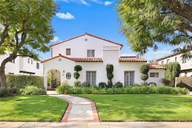 mediterranean / spanish house featuring a front lawn