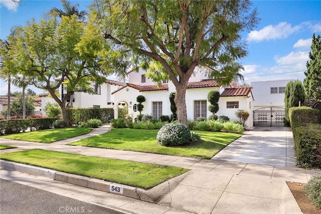 mediterranean / spanish home featuring a front lawn