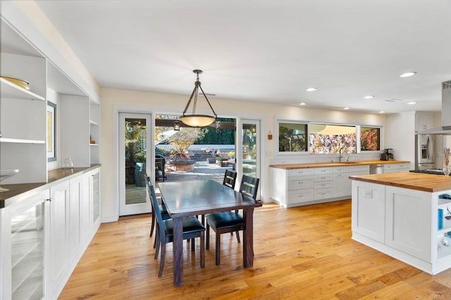 dining area with sink, beverage cooler, and light hardwood / wood-style floors