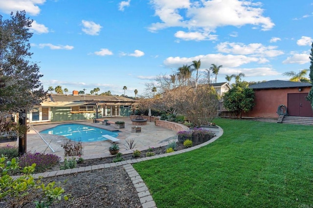 view of pool with a fire pit, a yard, and a patio area