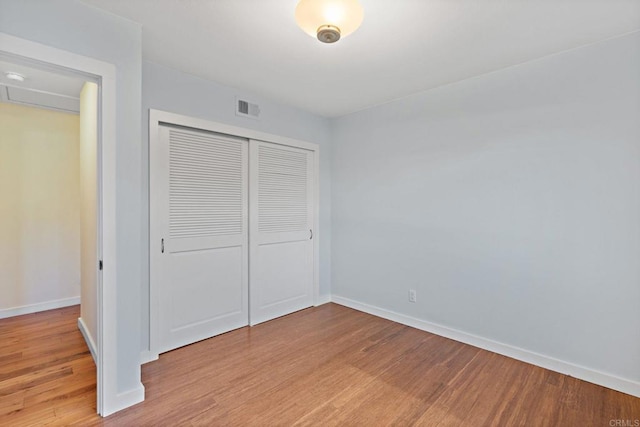 unfurnished bedroom with a closet and light wood-type flooring