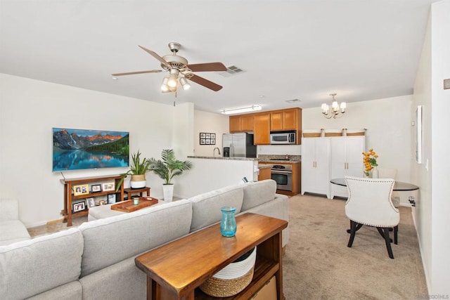 carpeted living room featuring ceiling fan with notable chandelier