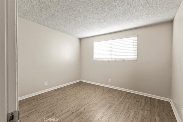 empty room featuring hardwood / wood-style flooring and a textured ceiling