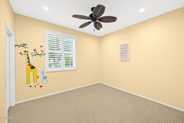 carpeted spare room featuring ceiling fan