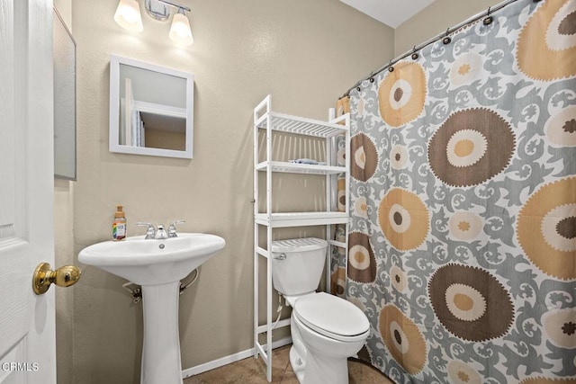 bathroom featuring a shower with curtain, tile patterned floors, and toilet