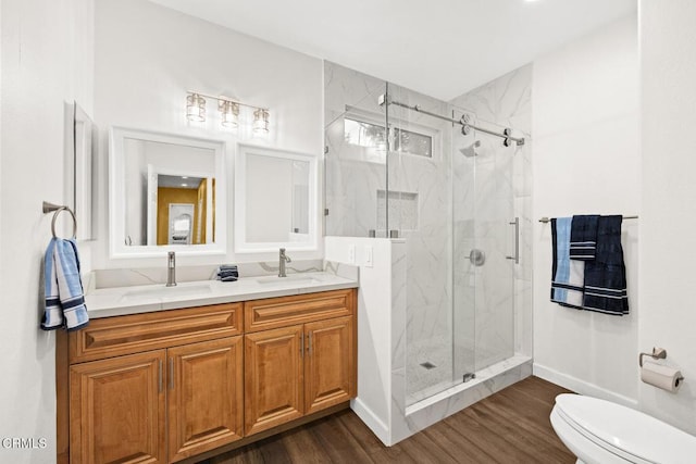 bathroom featuring wood-type flooring, vanity, walk in shower, and toilet