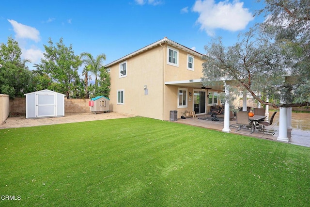 rear view of property with a yard, cooling unit, ceiling fan, a storage unit, and a patio