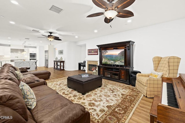 living room featuring ceiling fan and light hardwood / wood-style flooring