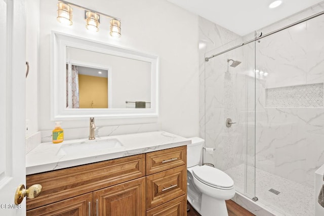 bathroom with vanity, toilet, and a shower with shower door