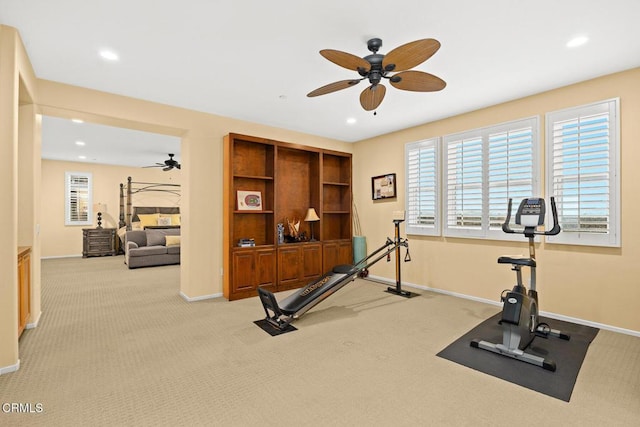 exercise room with ceiling fan and light colored carpet