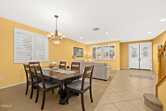 dining room featuring light tile patterned flooring and a notable chandelier