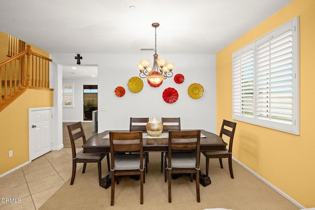 tiled dining space with an inviting chandelier