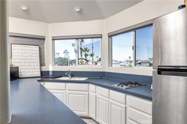 kitchen featuring stainless steel refrigerator, white cabinetry, gas cooktop, and sink