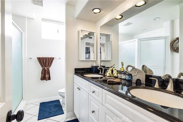 bathroom featuring vanity, toilet, tile patterned flooring, and a shower with door