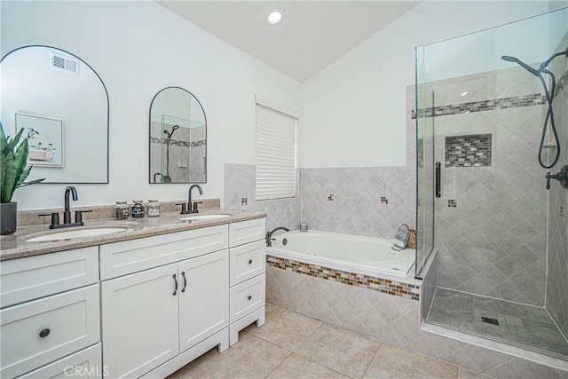 bathroom with vanity, vaulted ceiling, tile patterned floors, and shower with separate bathtub