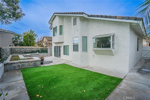 rear view of house with a yard and a patio