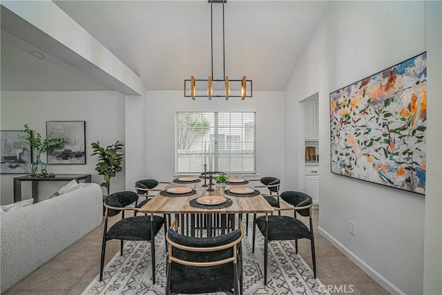 carpeted dining space with lofted ceiling