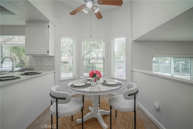 tiled dining area with sink and ceiling fan