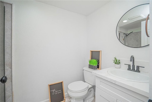 bathroom with vanity, toilet, and tiled shower