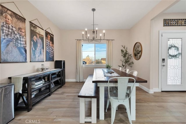 dining area with a chandelier and light hardwood / wood-style floors