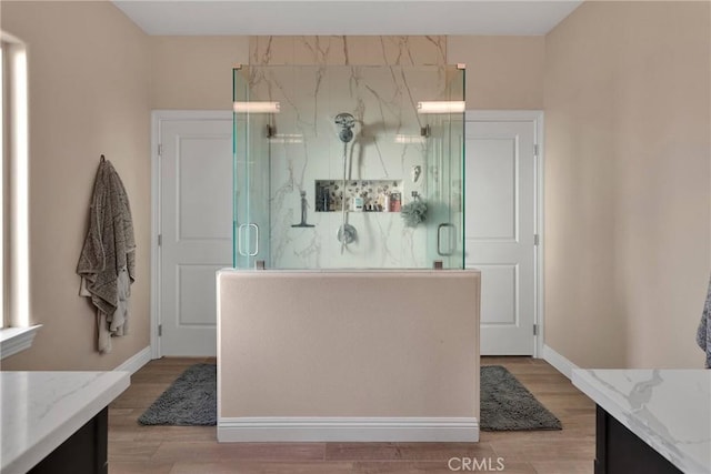 bathroom with vanity, a shower with shower door, and hardwood / wood-style floors