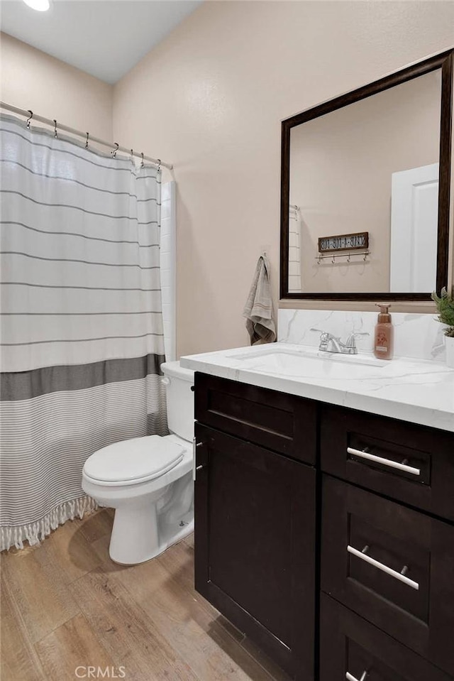 bathroom featuring vanity, hardwood / wood-style floors, toilet, and a shower with shower curtain