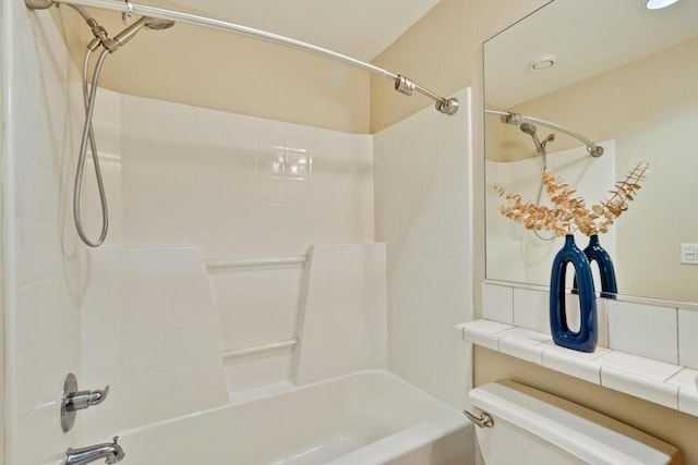 bathroom featuring tub / shower combination and toilet