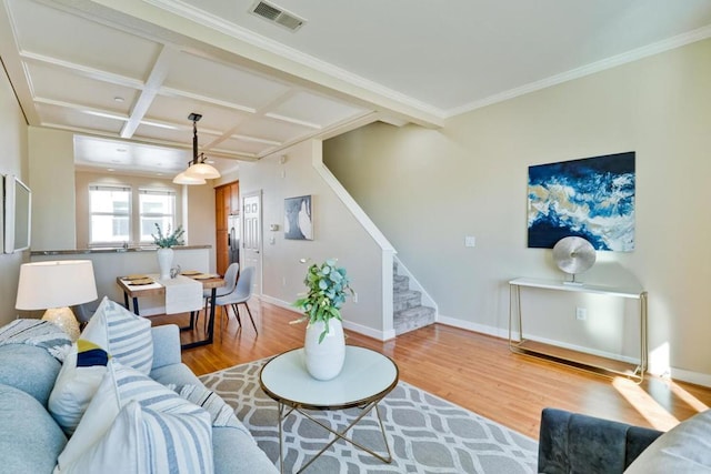 living room featuring beamed ceiling, ornamental molding, coffered ceiling, and light hardwood / wood-style flooring