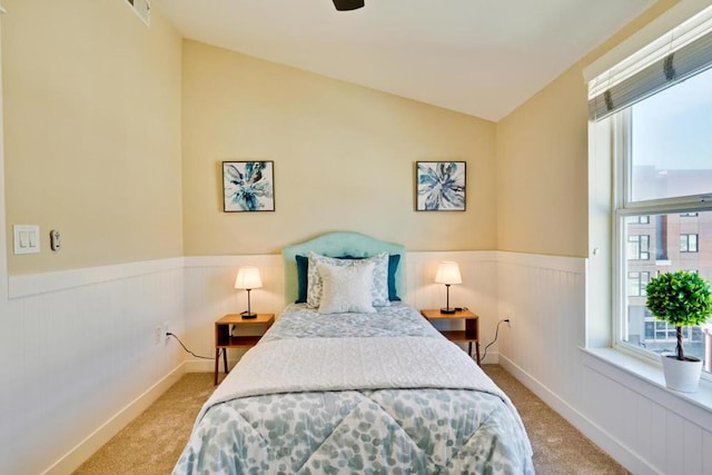 carpeted bedroom with vaulted ceiling and multiple windows