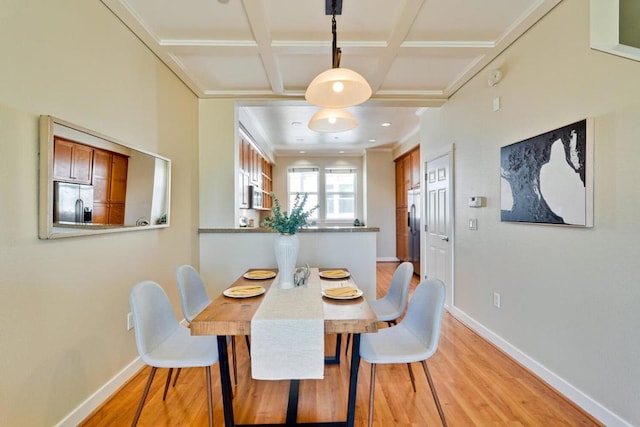 dining space featuring beamed ceiling, coffered ceiling, and light hardwood / wood-style flooring