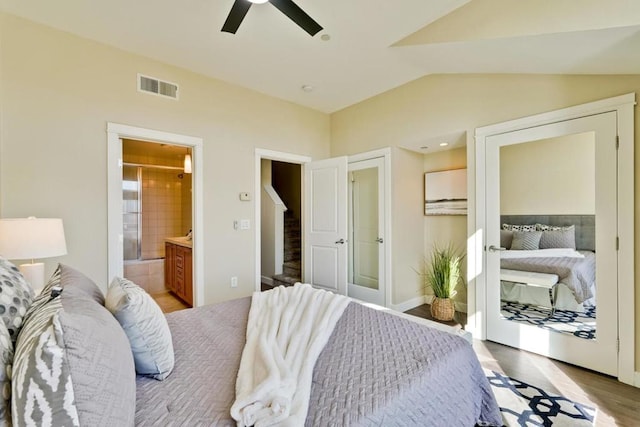 bedroom with lofted ceiling, light hardwood / wood-style flooring, ceiling fan, and ensuite bathroom