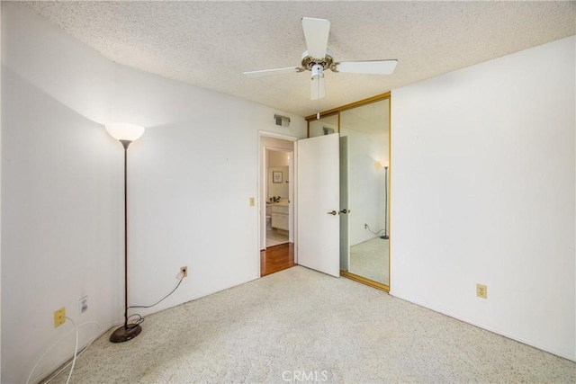 unfurnished bedroom featuring ceiling fan, carpet, a textured ceiling, and a closet