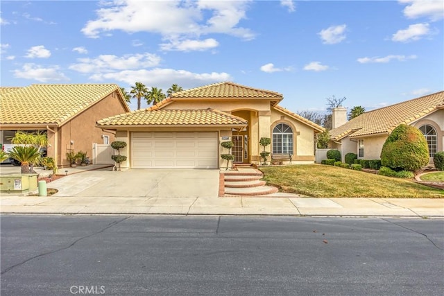 mediterranean / spanish house with a garage and a front yard