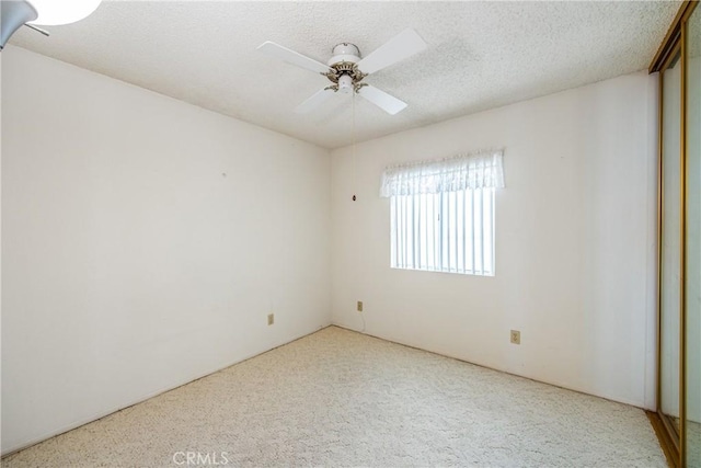 spare room with a ceiling fan, carpet floors, and a textured ceiling