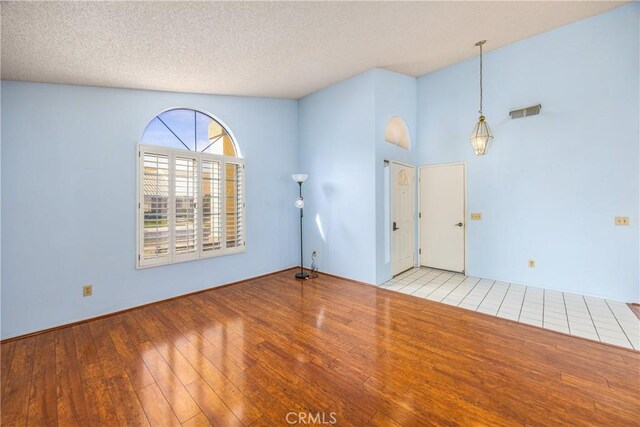 unfurnished room featuring light hardwood / wood-style floors and a textured ceiling