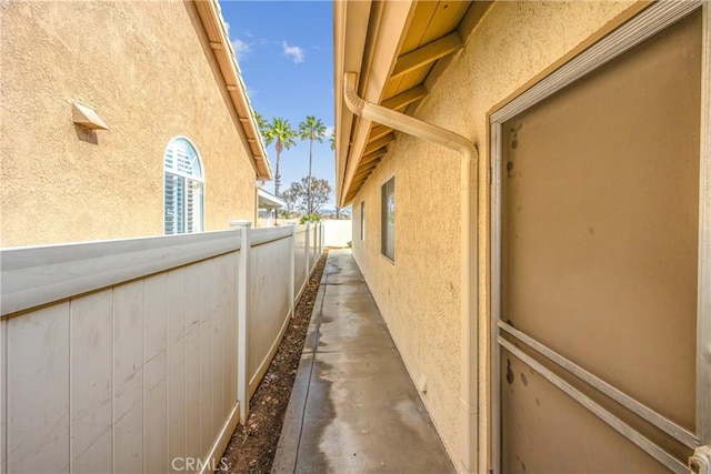 view of side of property with fence and stucco siding