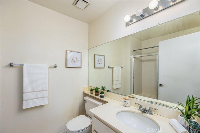 bathroom featuring a shower with door, vanity, and toilet