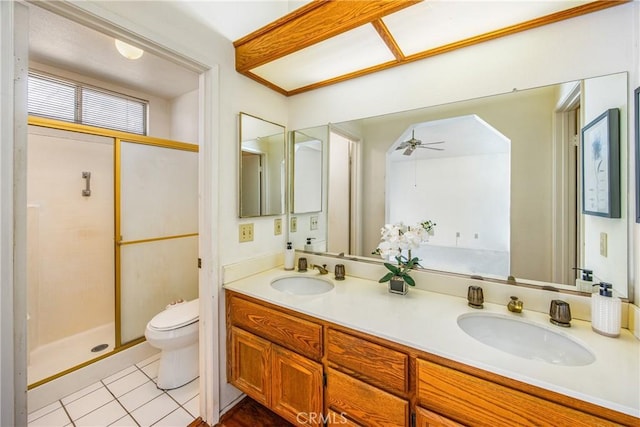 bathroom featuring a shower with door, ceiling fan, vanity, tile patterned floors, and toilet