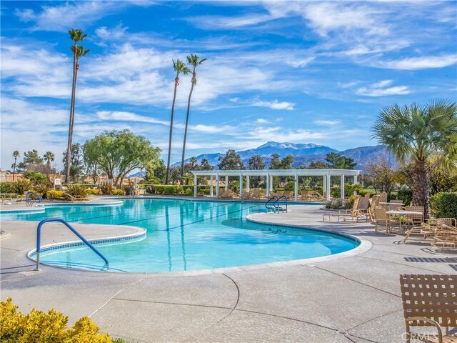 view of swimming pool featuring a patio and a mountain view