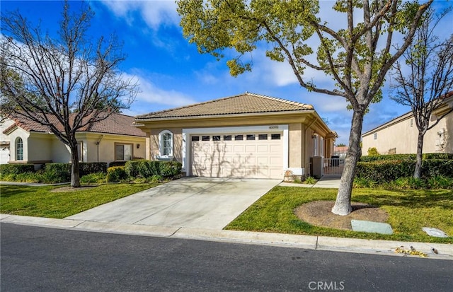 mediterranean / spanish home with a garage and a front lawn