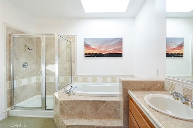 bathroom with vanity, shower with separate bathtub, and a skylight