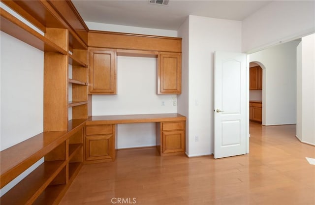 kitchen featuring built in desk and light wood-type flooring