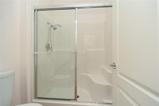 bathroom featuring an enclosed shower and toilet