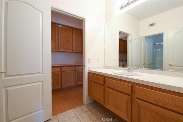 bathroom featuring vanity, an enclosed shower, and tile patterned flooring