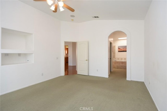 unfurnished bedroom with carpet floors, ceiling fan, and ensuite bathroom