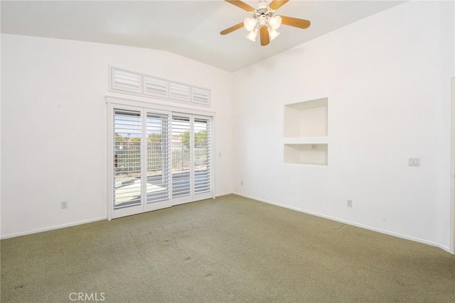 carpeted spare room featuring vaulted ceiling, built in features, and ceiling fan