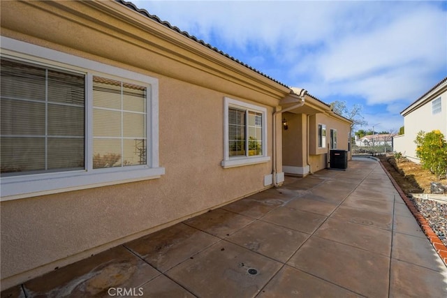 view of side of home with a patio and central AC unit