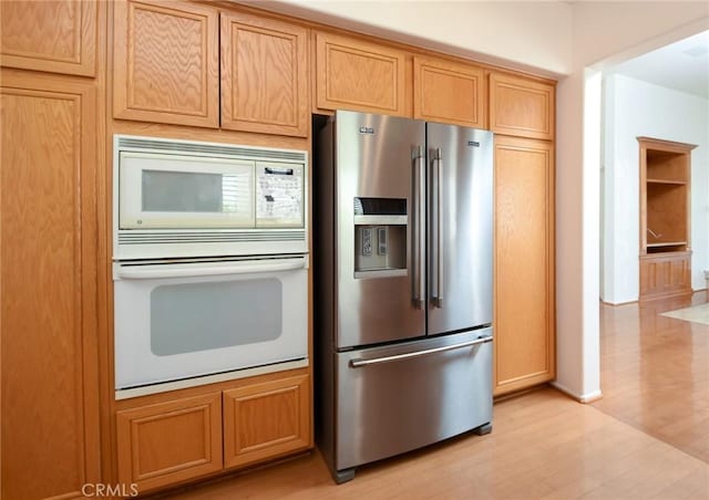 kitchen featuring white appliances and light hardwood / wood-style flooring